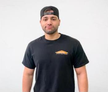 male in black servpro shirt with a backwards hat